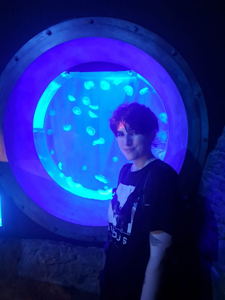 Hannah beside a jellyfish aquarium after overcoming her fear of jellyfish